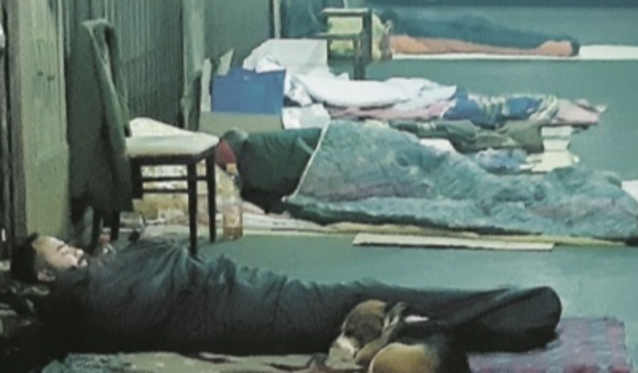 Alcuni clochard davanti alle serrande chiuse di via Conte Verde