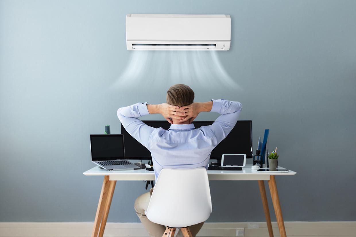 Happy Businessman Relaxing In Office With Air Conditioning