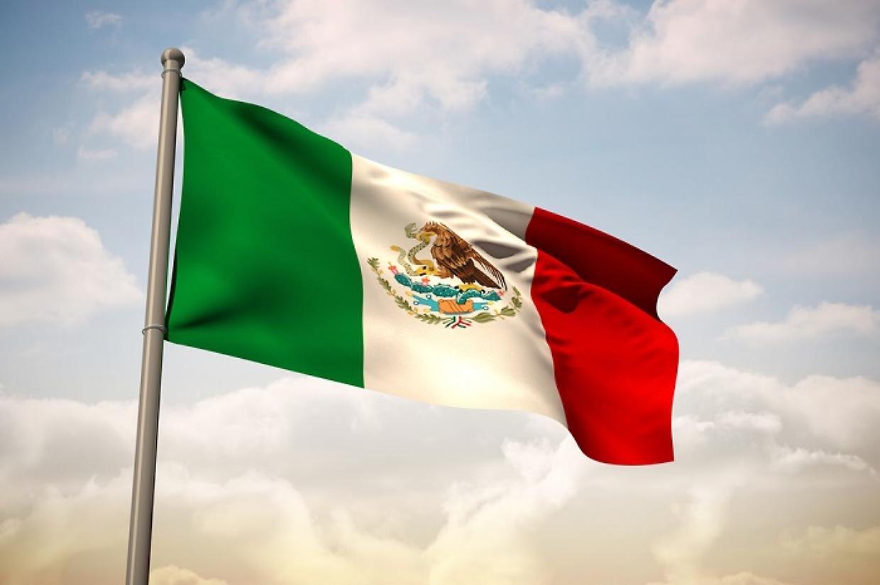 Mexico national flag against beautiful blue sky with clouds