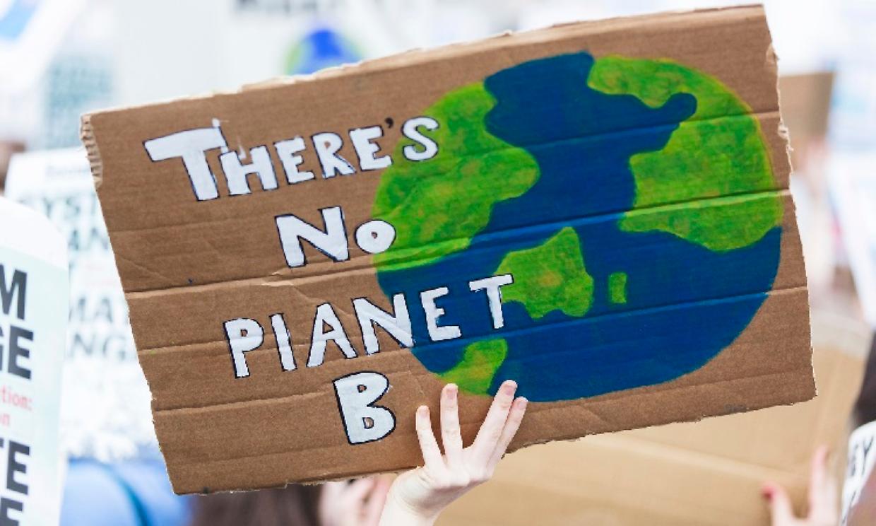 People with banners protest as part of a climate change march