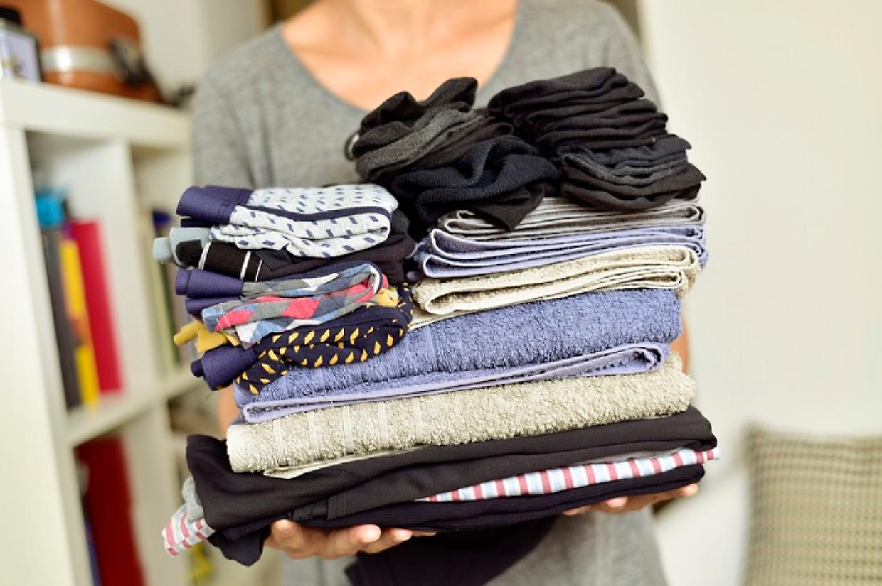 young man with a pile of folded clothes