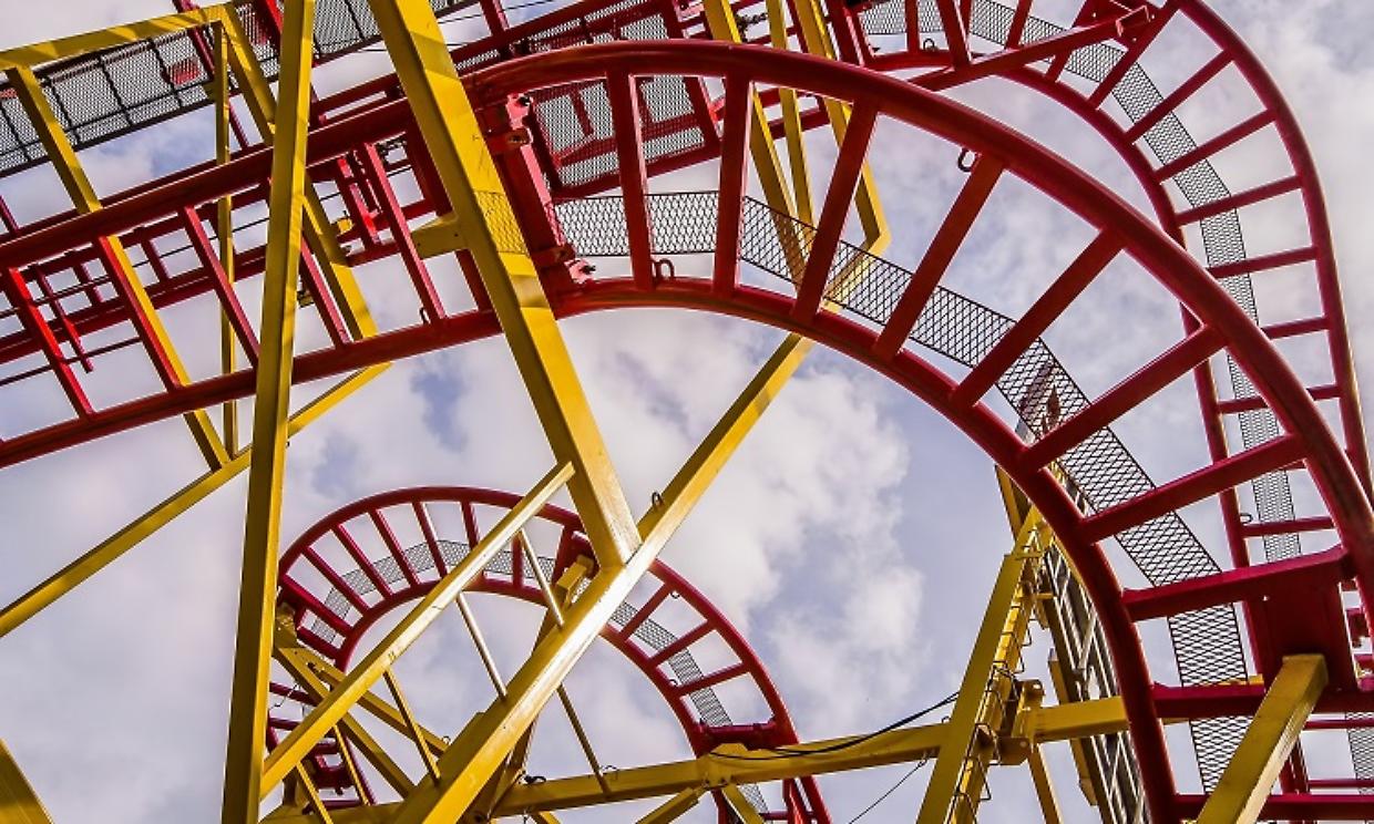 montagne russe dp Low angle shot of a roller coaster ride with a cloudy sky in the background