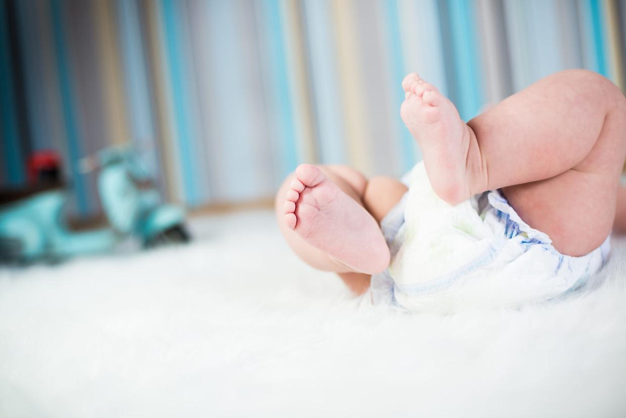 bambino pannolino bimbo neonato Newborn baby in diaper lying on plush blanket