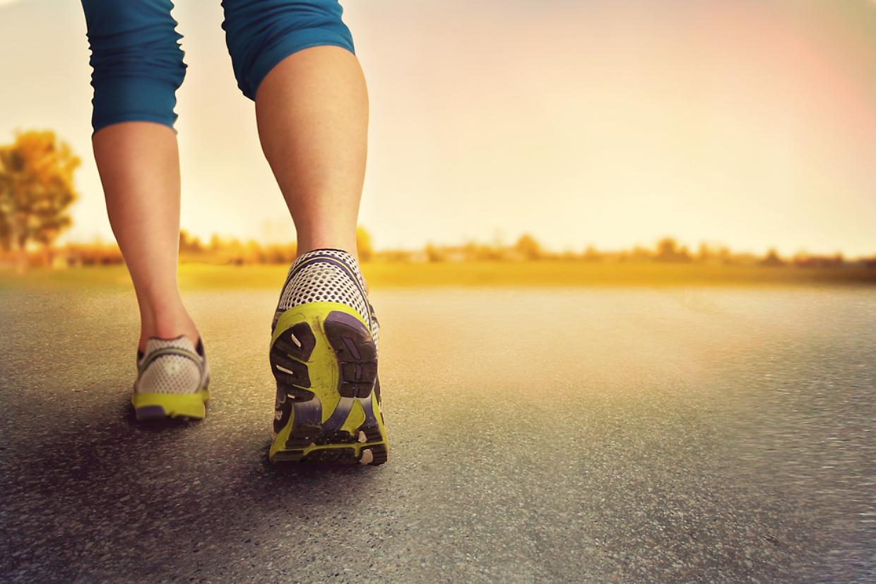 jogging corsa an athletic pair of legs on pavement during sunrise or sunset -
