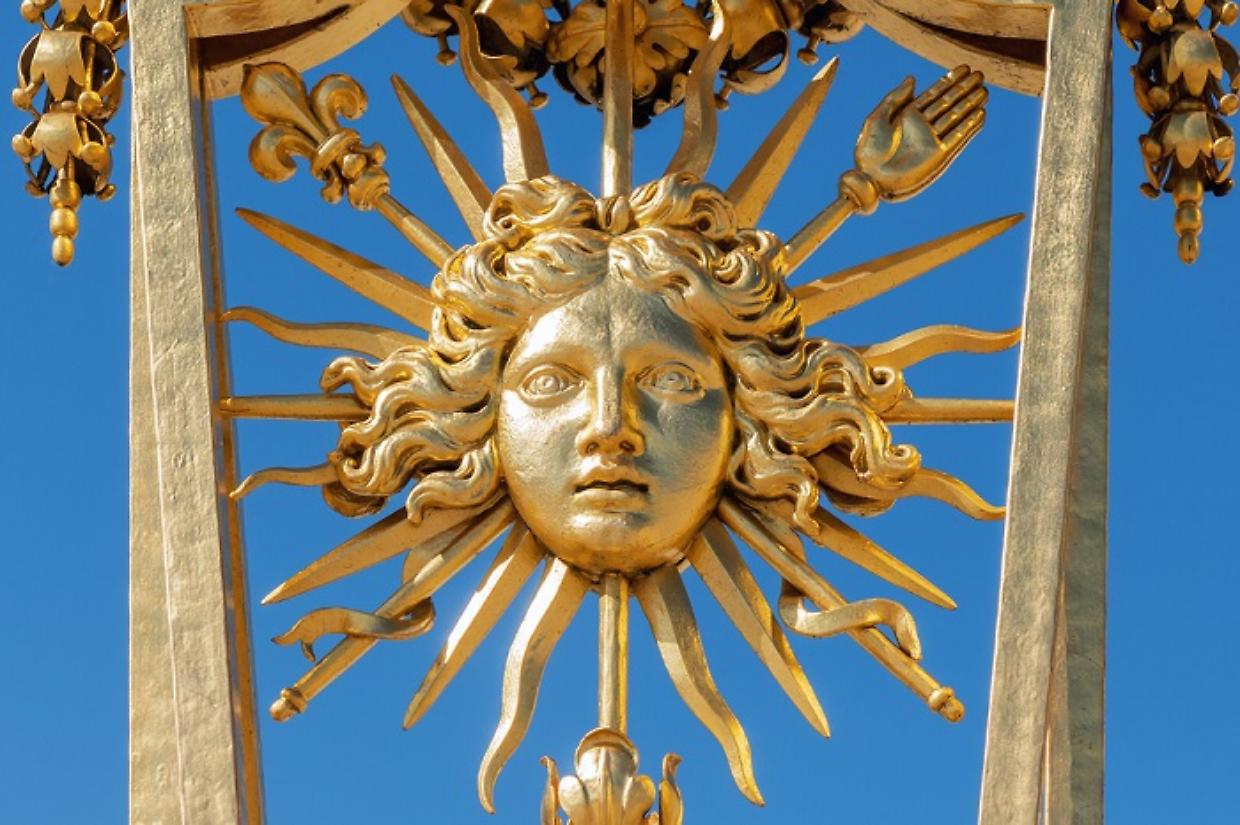 Symbol of Louis XIV the Sun King on the golden gate of Versailles Castle