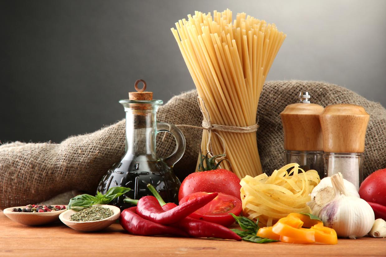 Pasta spaghetti, vegetables and spices, on wooden table, on grey background