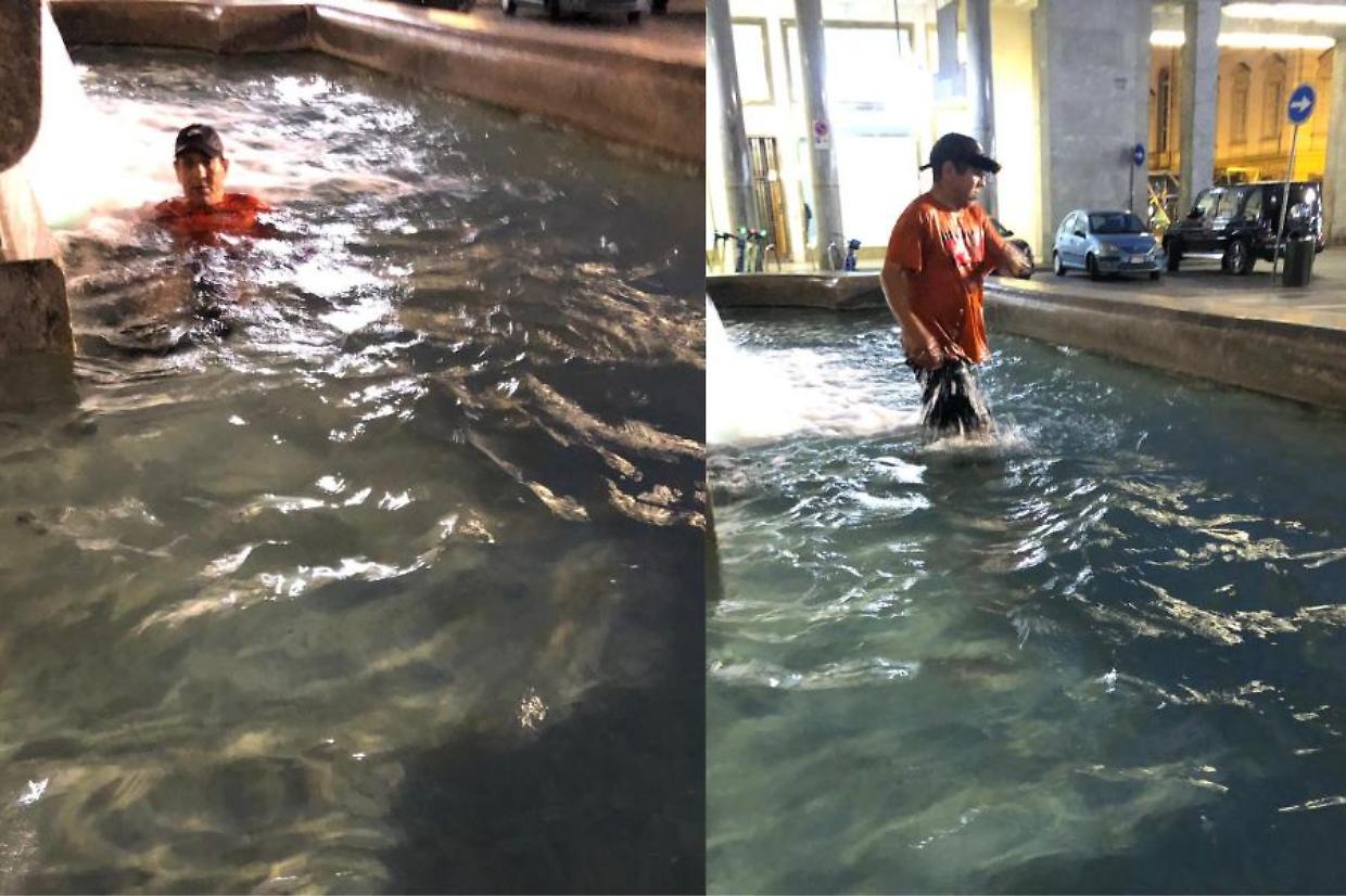 L'uomo immortalato mentre fa il bagno nella fontana Dora,