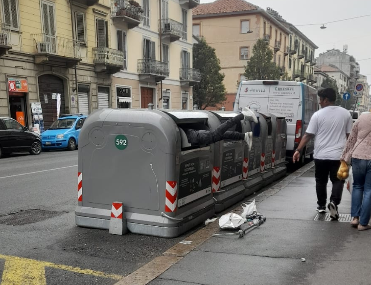 Un uomo beccato con testa e corpo dentro a un bidone