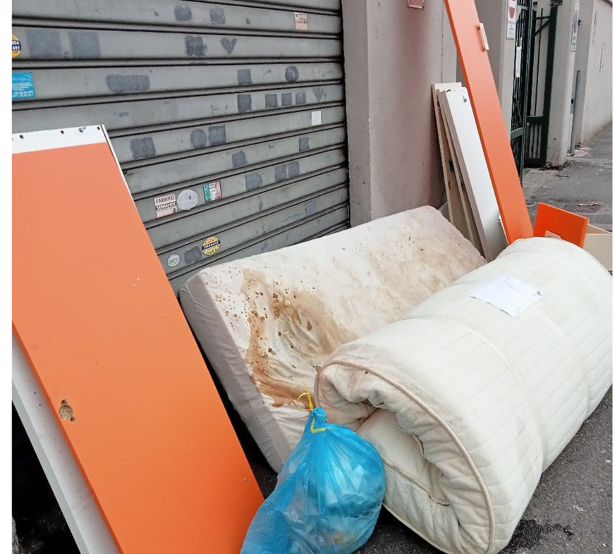materassi e pannelli abbandonati sul marciapiede