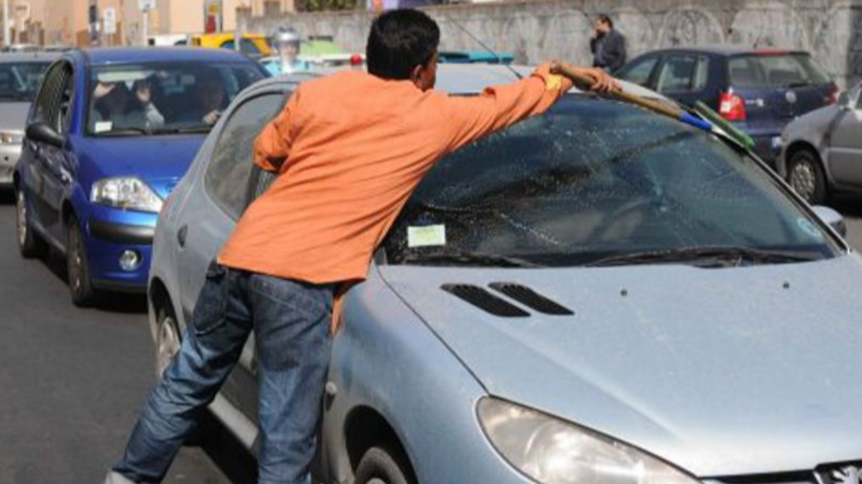 Pulisce il parabrezza e chiede soldi