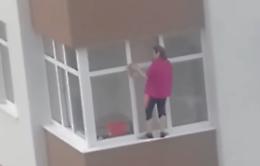 In bilico sul davanzale per… pulire i vetri! La scena è choc