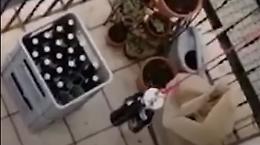 Vedono le bottiglie al piano di sotto e s'inventano un trucco per portarle su