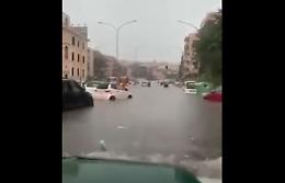 Piove a dirotto e l'ampio viale si trasforma in un fiume