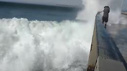 L'onda gigante "annaffia" i turisti fermi sul pontile