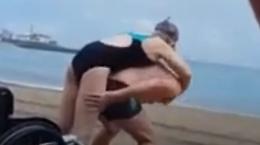 Si carica la moglie sulle spalle e la porta al mare