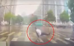 Corre per bruciare il semaforo pedonale ma scivola sulle strisce e cade a terra!!