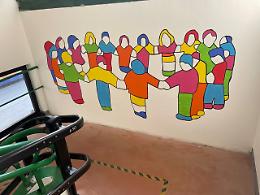 I bimbi dipingono l’opera donata dall'artista alla scuola d'infanzia