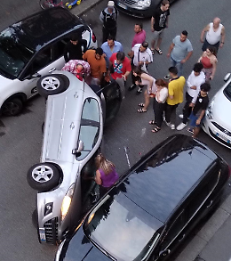 A tutta velocità colpisce un'auto ferma e si cappotta in mezzo alla strada