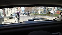 Gruppo di piccoli teppisti in bicicletta contro le auto parcheggiate in strada