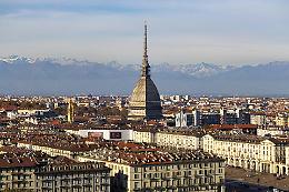 Torino a testa in su: i tre volti del potere sulle facciate di Via Milano che hanno occhi (e zanne)