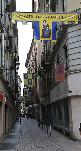 Cosa significano le bandiere della Contrada dei Guardinfanti? Il mistero di un nome nato per proteggere la vita (e nascondere scandali)