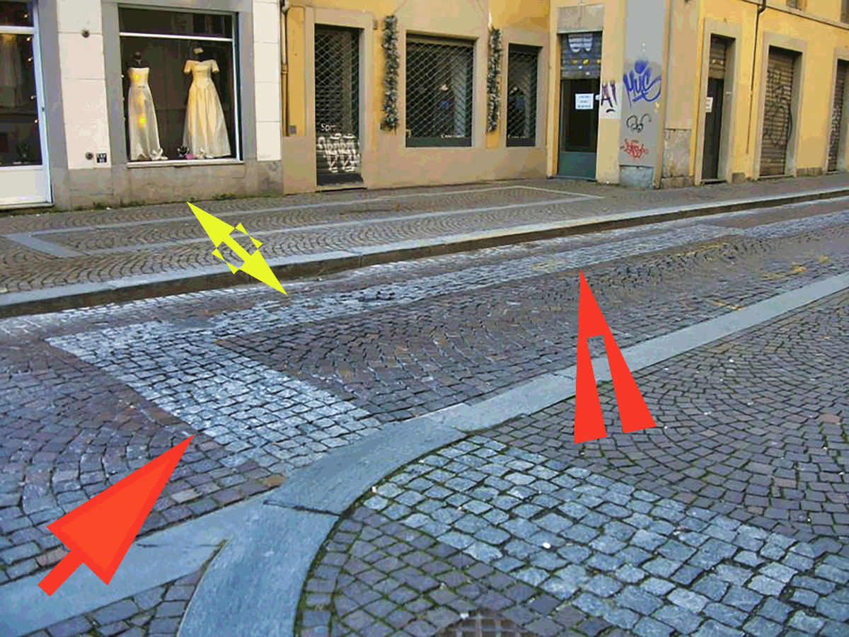 Le frecce rosse indicano i sampietrini che delimitano la parte tagliata di palazzo Barolo