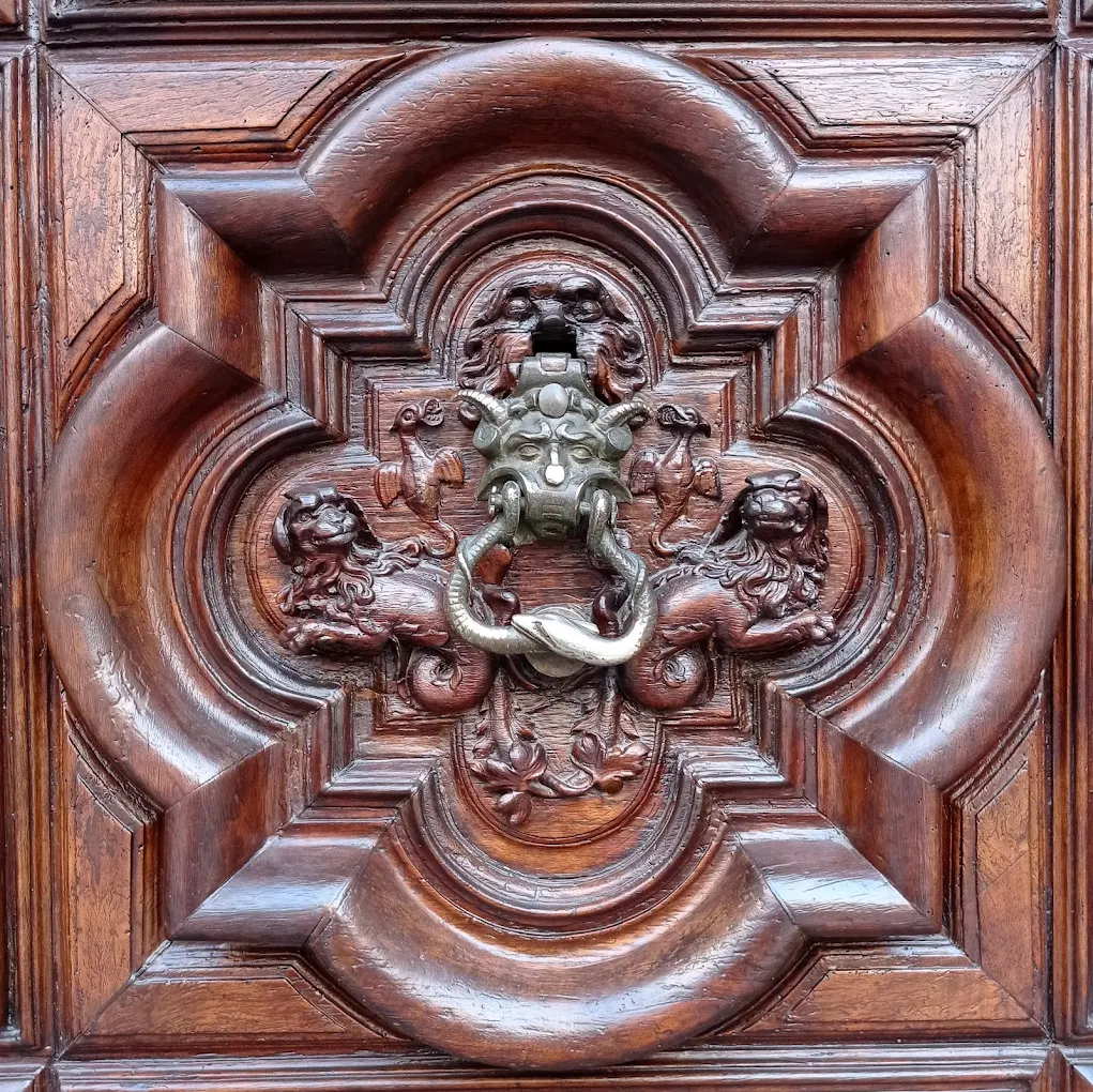 L’espressione non ha origini ufficiali, ma deriva dalla presenza di un batacchio in bronzo raffigurante un volto demoniaco, tradizionalmente associato a Satana