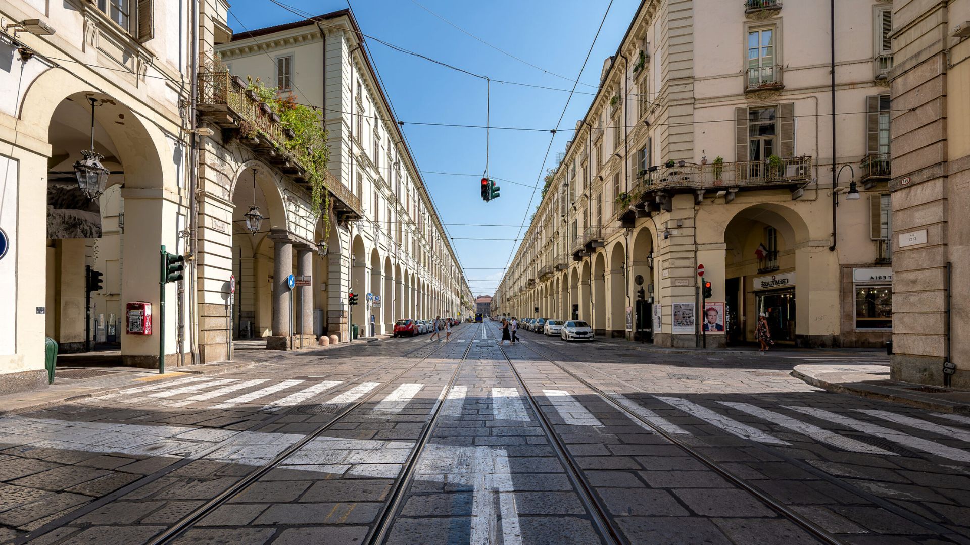 Osservando con attenzione, emerge una differenza tra i due lati: i portici sul lato sinistro risultano continui, mentre quelli sul lato destro presentano interruzioni lungo il percorso, con tratti scoperti tra un edificio e l’altro